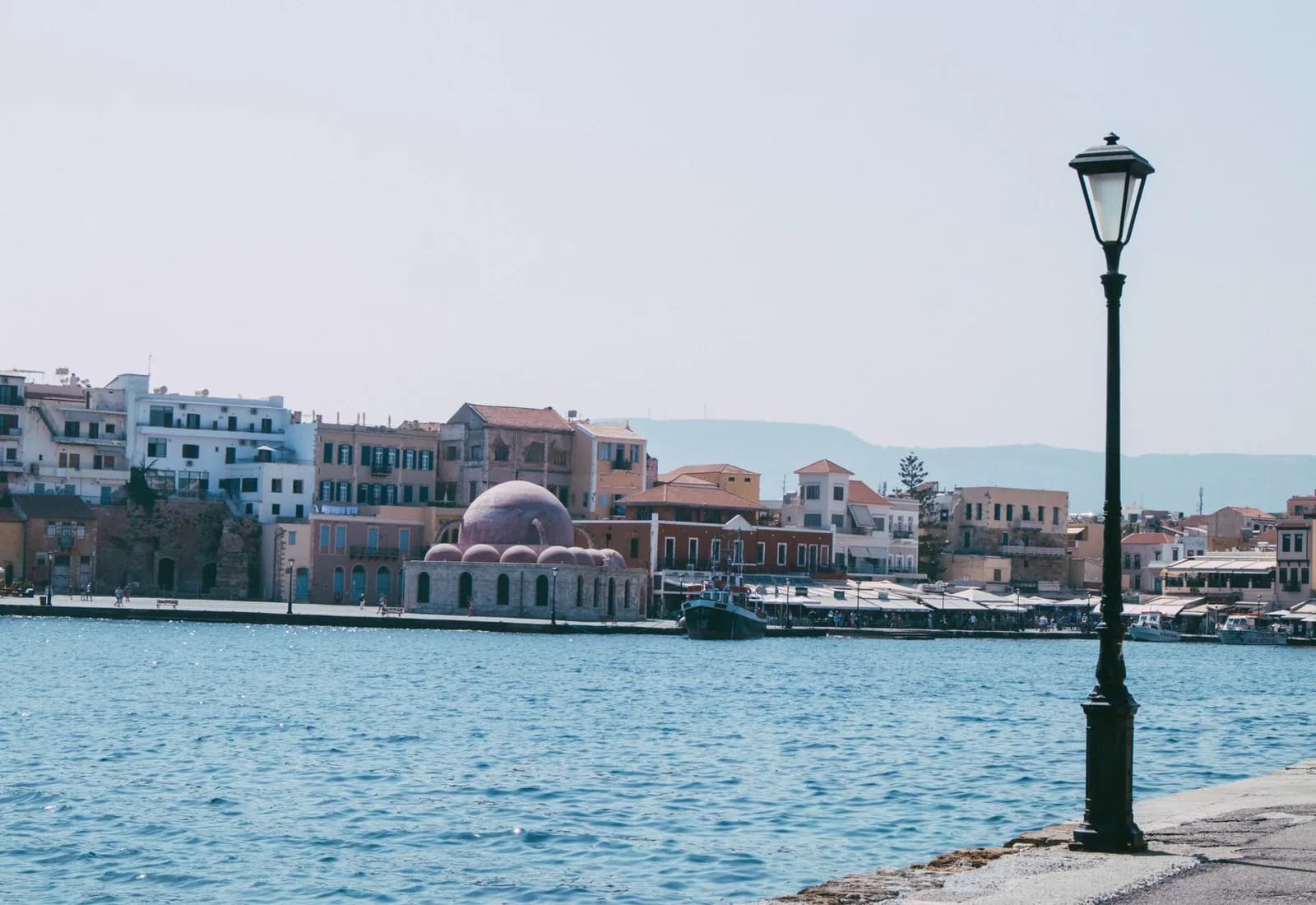 Beautiful waterfront view of Chania with historic architecture and blue sea.