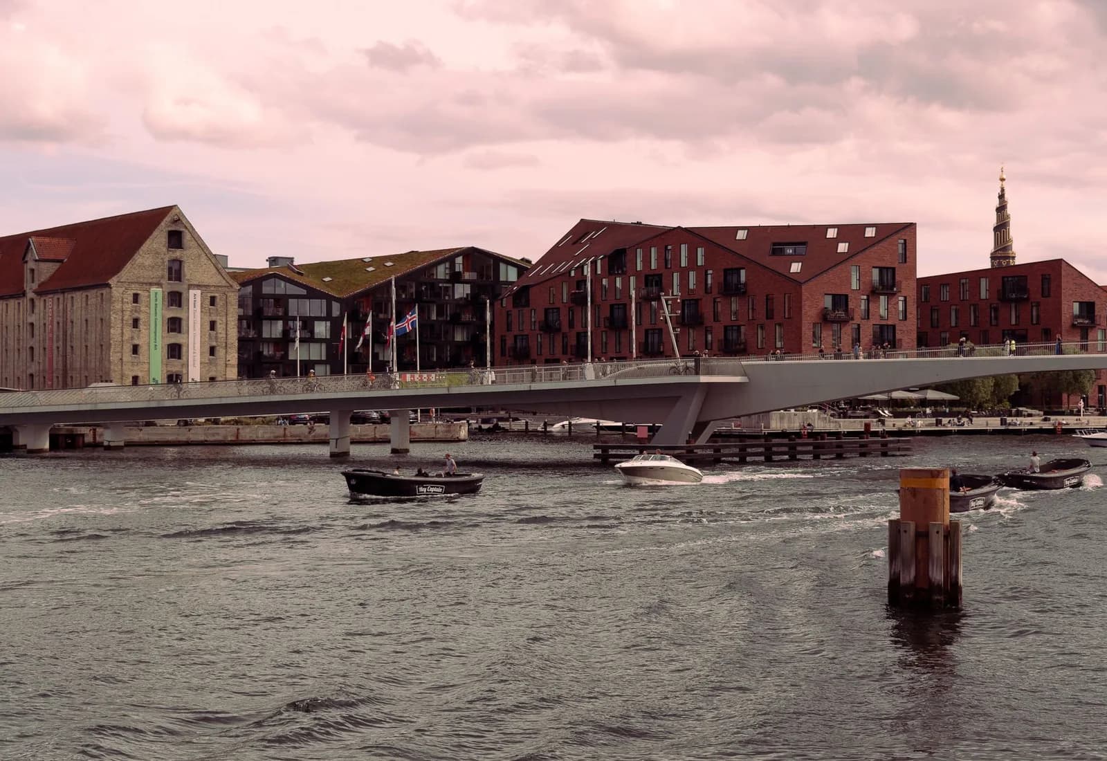 Scenic view of Inderhavnsbroen bridge and waterfront buildings in Copenhagen at dusk.