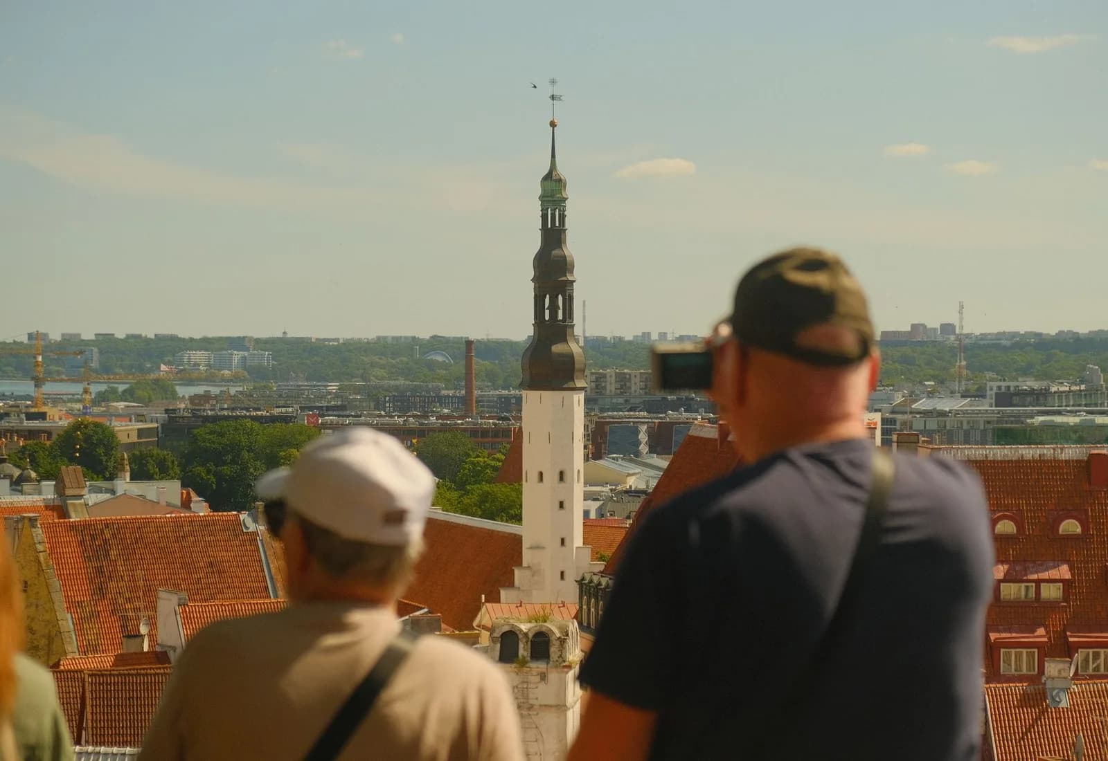 Tourists overlook the scenic skyline of Tallinn, capturing the historic architecture under a clear day.